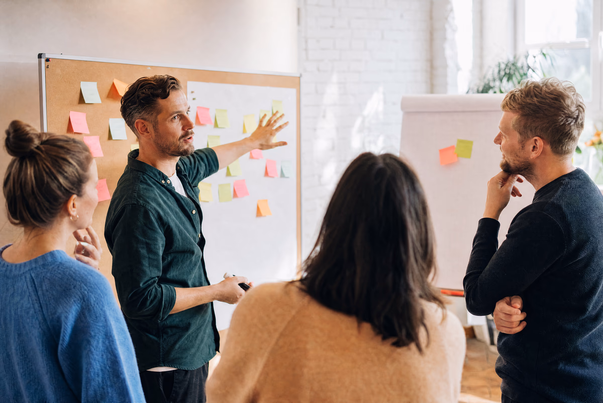 Workshop-Gruppe arbeitet an Pinwand und Flipchart