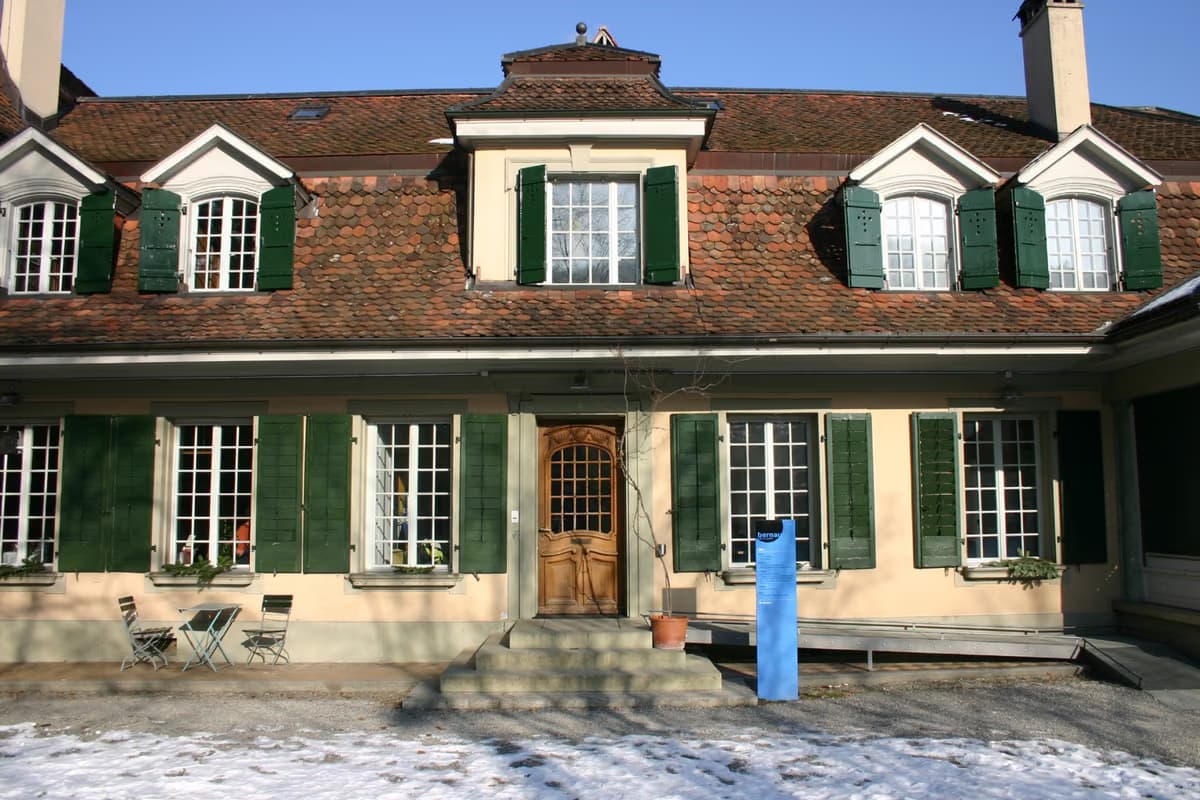 Fassade der Villa Bernau mit grünen Fensterläden und Eingangsbereich
