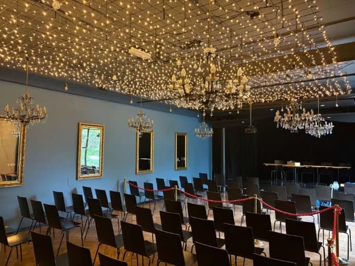 Spiegelsaal mit Stuhlreihen, Bühne und Sternenhimmel
