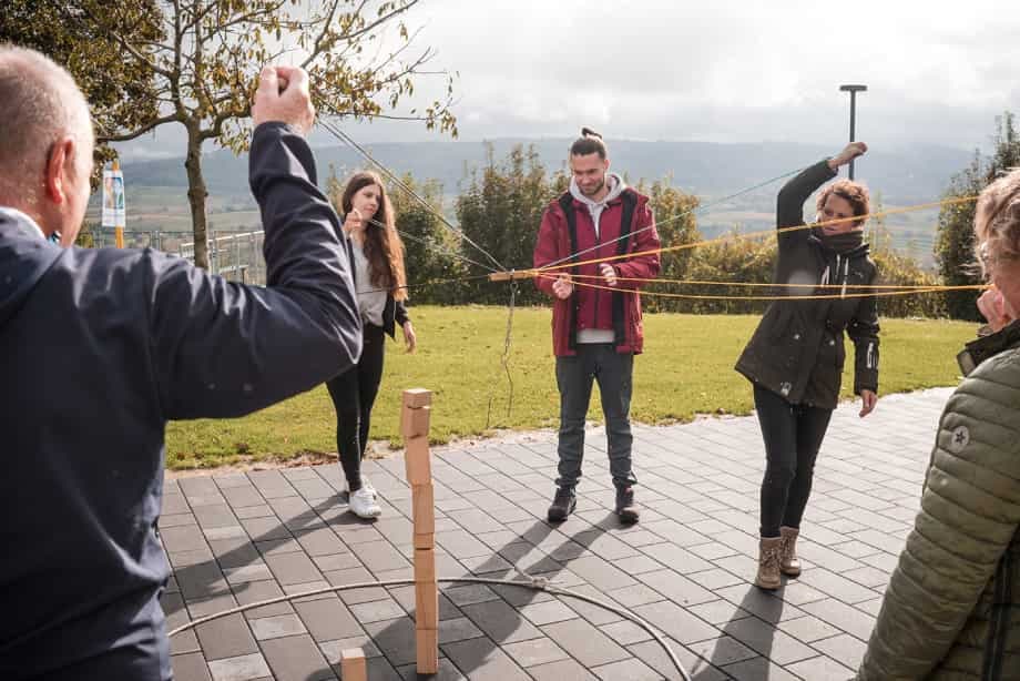 Teilnehmende bei der BITOU-Teamolympiade im Freien: Koordination am Seilnetz.