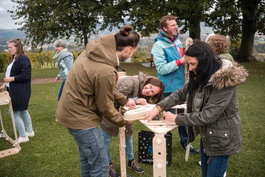 Teilnehmende bauen gemeinsam ein Windrad beim BITOU-Teamevent: Bauteile verbinden.