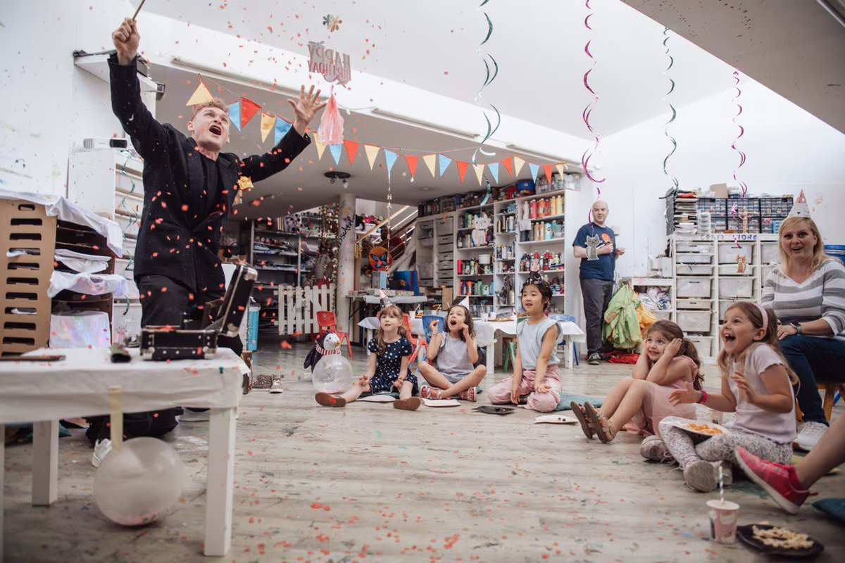 Kinder beim Kindergeburtstag beobachten staunend eine Zaubershow in der Schweiz