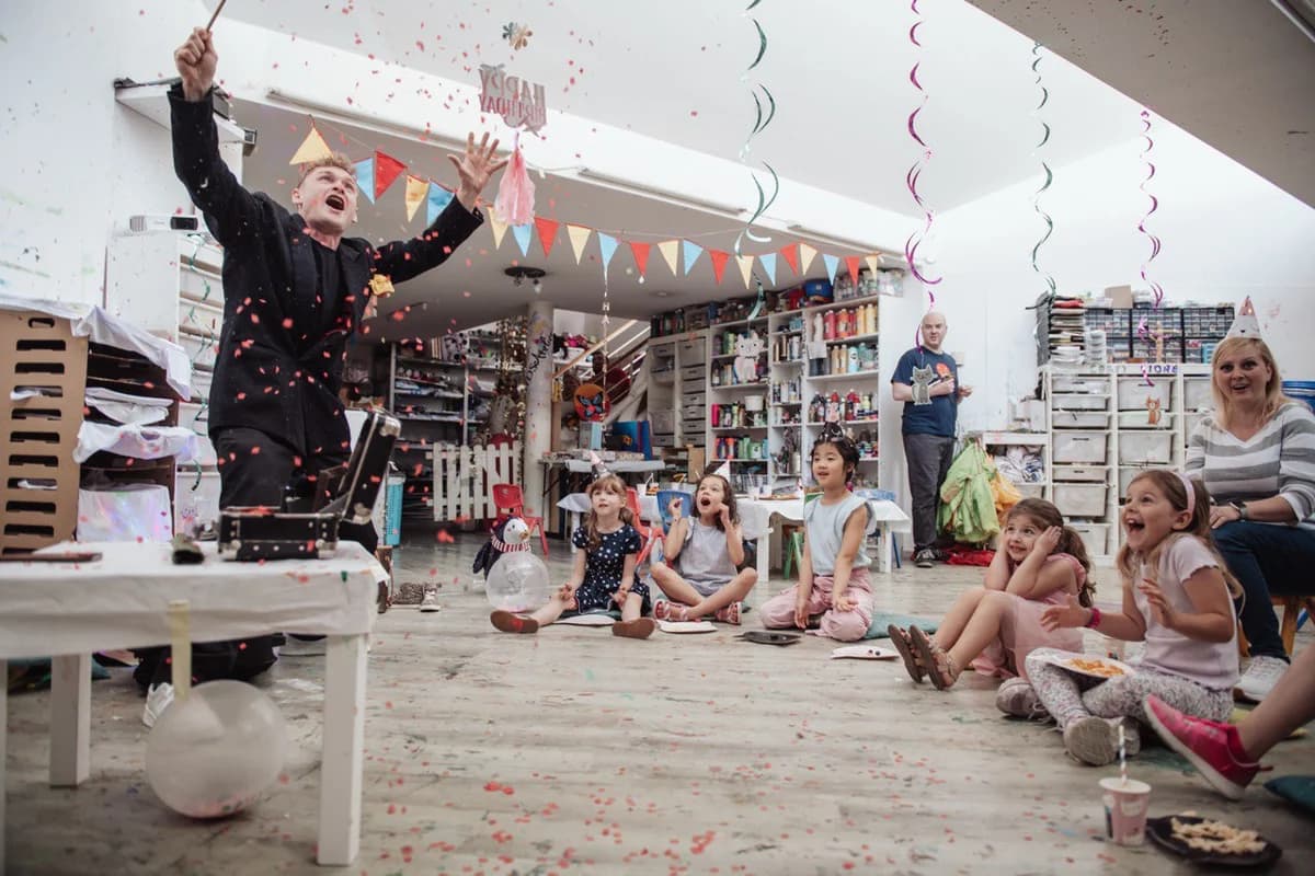 Kinder beim Kindergeburtstag beobachten staunend eine Zaubershow in der Schweiz