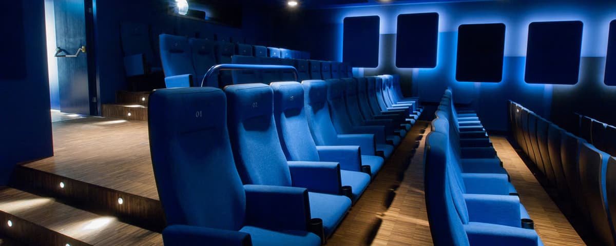 Blauer Kinosaal mit gepolsterten Sitzreihen im kult.kino atelier