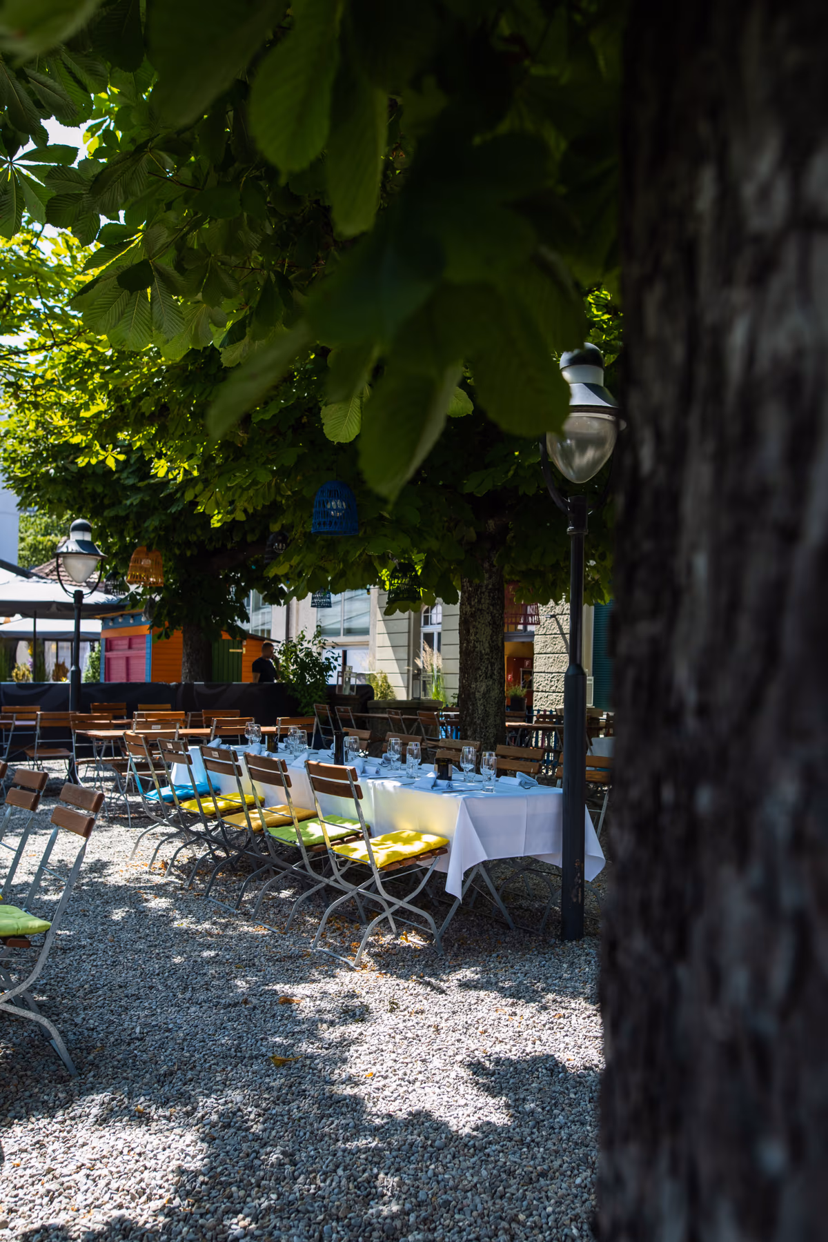 Gedeckte Tische unter Bäumen in Gustavs Biergarten