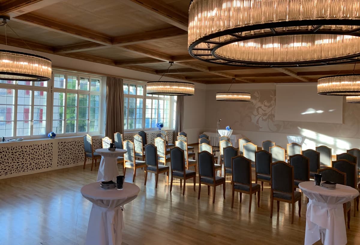 Grosser Saal mit Stühlen, Stehtischen und Kronleuchtern